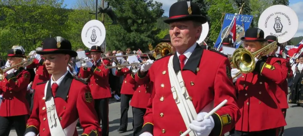 Kongsberg Våpenfabrikks Musikkorps marsjerer og spiller instrumenter på 17. mai