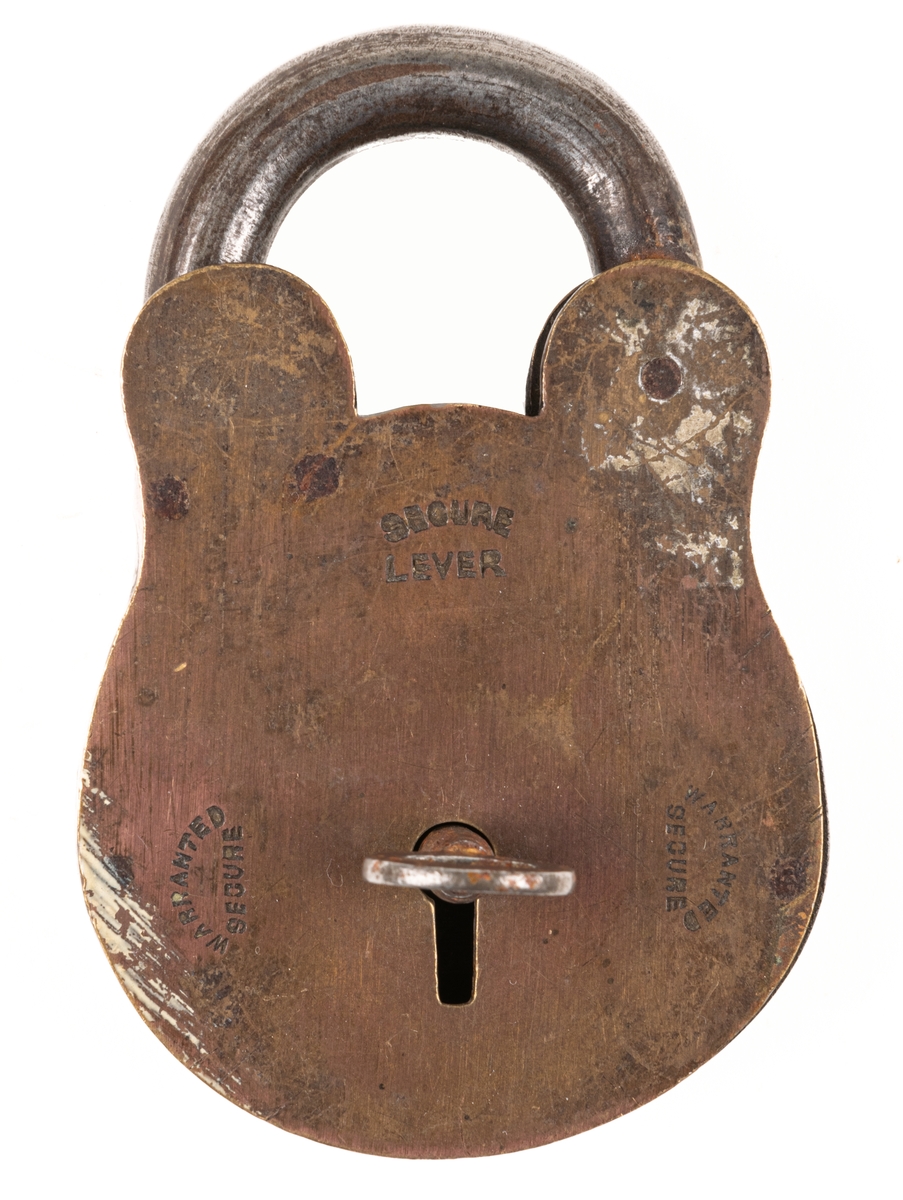 Lås, järn och mässing. Rundat nedtill. Nyckelhål på sidan med fastsittande nyckel. Märkt "Secure lever", "Warranted secured". Största bredd 6,4 cm.