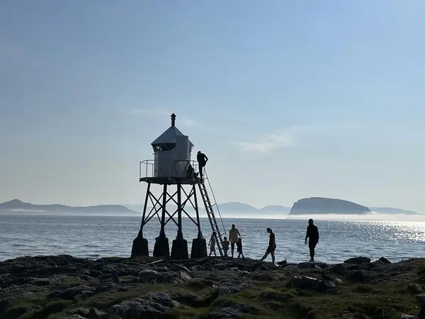 Silhuetter av mennesker ved fyret ved Fuglenesodden.