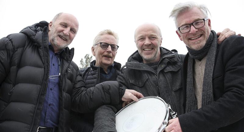 Fire menn som er medlemmer av musikkgruppa Knallkameratene. De holder ei skarptromme.