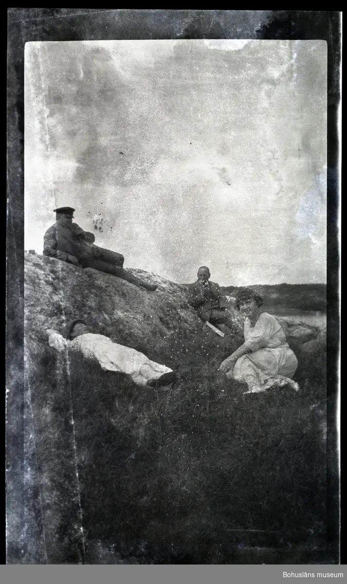Fyra personer sitter på en klippa.