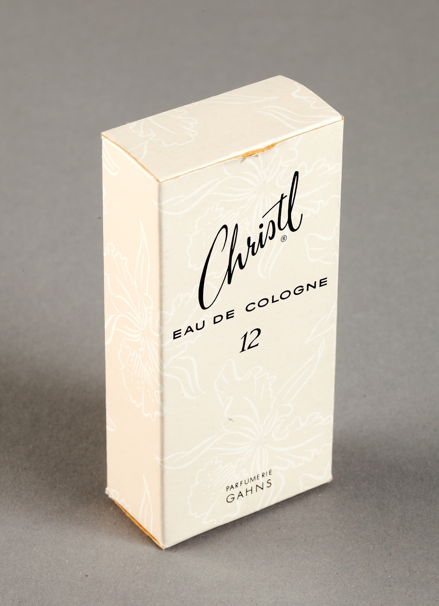 Förpackning av papp med tryckt blommönster i rosa och vitt och svart text: "Christl EAU DE COLOGNE 12 Parfumerie Gahns, Förtjusande...med en doft som talar omkultur och förfining...det är Christl från Gahns."