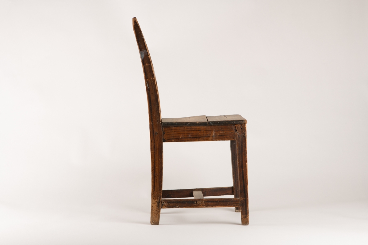 Barnestol i tre som ser ut som "voksenstol". Setet smalner mot ryggen som er buet. Stolen er ganske slitt og har enkelte hvite malingflekker.