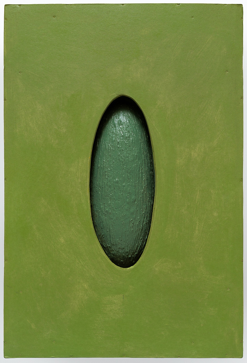 Grønn, rektangulær form med ellipseformet hull i midten. Nede i hullet er det plassert et ellipseformet objekt.
