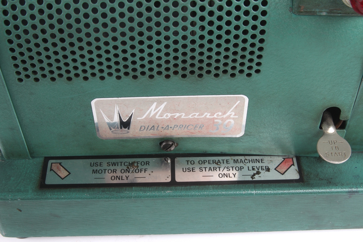 Prismerking apparat til bruk i butikk av typen "Monarch Dial a pricer 39". Apparatet er lakkert i en grønn "krympelakk".