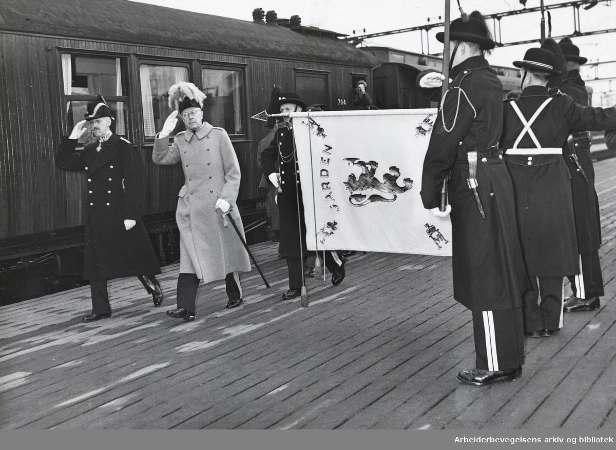 Kong Gustav VI Adolf besøker Oslo. Mars 1952. Mottas på Østbanestasjonen av Kong Haakon VII og Hans Majestet Kongens Garde.