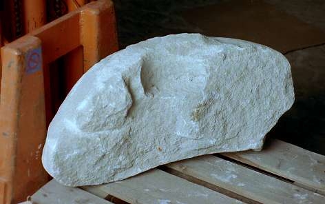 Dopfunt av vitaktig kalksten, bestående av två delar , med brottytor som rundats av ålder, rund skålform utan dekor.

