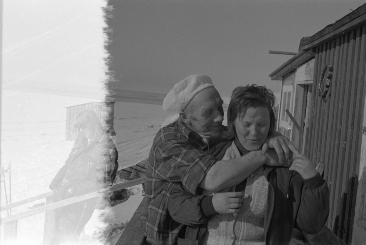 Mann og kvinne foran hytte.