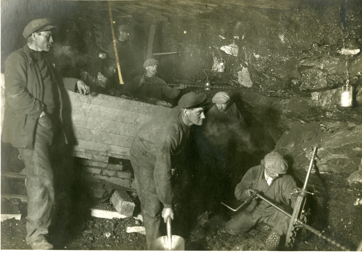 Postkort av gruvearbeidere i gruva i Ny- Ålesund i ca.1919, fotografert av Sigval Moa fra Ålesund. Bildet er fra bildesamlingen til Jens Kristoffer Bay, som var  disponent for Kings Bay Kul Kompani i 1917-1921.