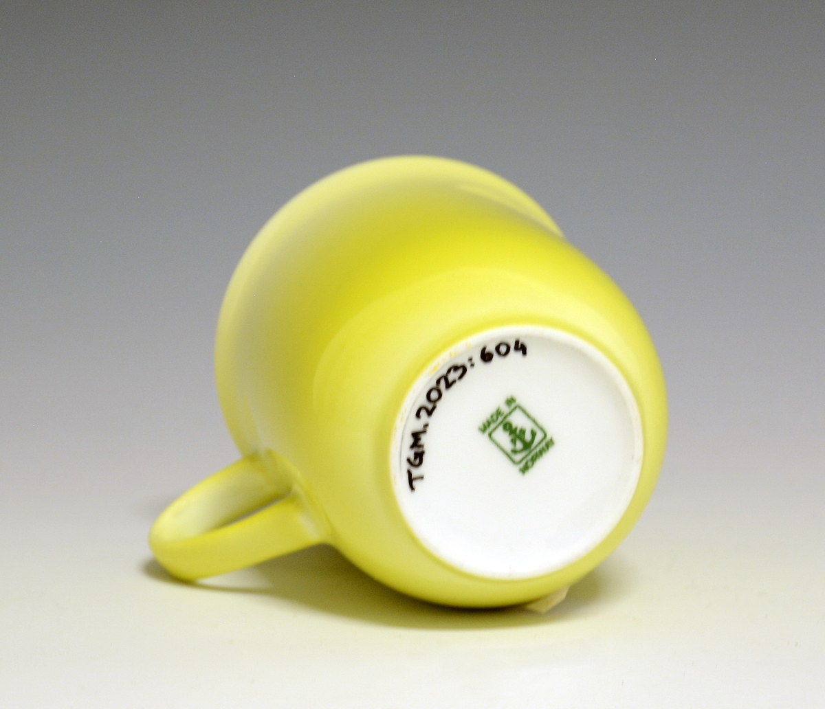 Krus av porselen med  hvit glasur. Heldekkende gul utvendig, innvendig "XL" med brede "penselstrøk". 
Modell: 2681