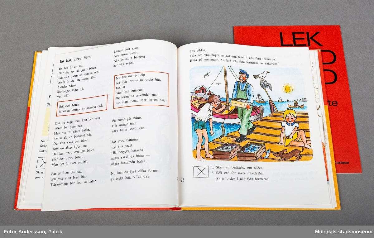 En bok med hård pärm i kvadratiskt format. Bokens fram och baksida har en längsgående linje i bokens horisontala mittlinje. Över mittlinjen är boken gul. Under mittlinjen är boken röd. Det finns en text med rubriken "Lek med ord". Samma bokstäver finns sammanblandade i oordning under mittlinjen. Boken innehåller färglagda bilder och läseövningar.
Boken är utgiven i slutet på 60-talet och är förmodligen en lärobok som använts av givaren under utbildning eller i sitt yrke som lärare. Till boken hör ochså ett lärarhäfte som ligger i boken.