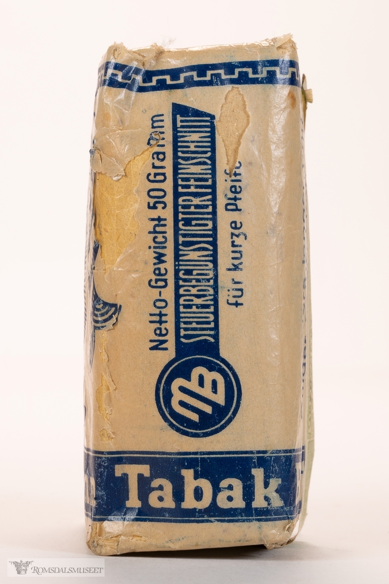 Rektangulær eske med pipetobakk. «Krigstobakk» av typen Translanta Spezial, Brinkmann Tabak. Pakken er uåpnet og inneholder 50 gram pipetobakk, beregnet for kort pipe («für kurze Pfeife»).