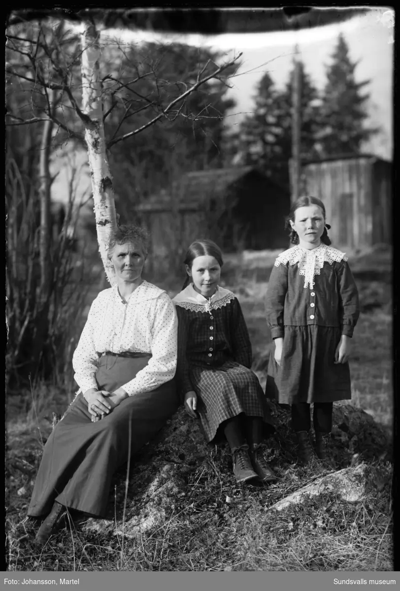 Porträttbild utomhus med en kvinna och två flickor.