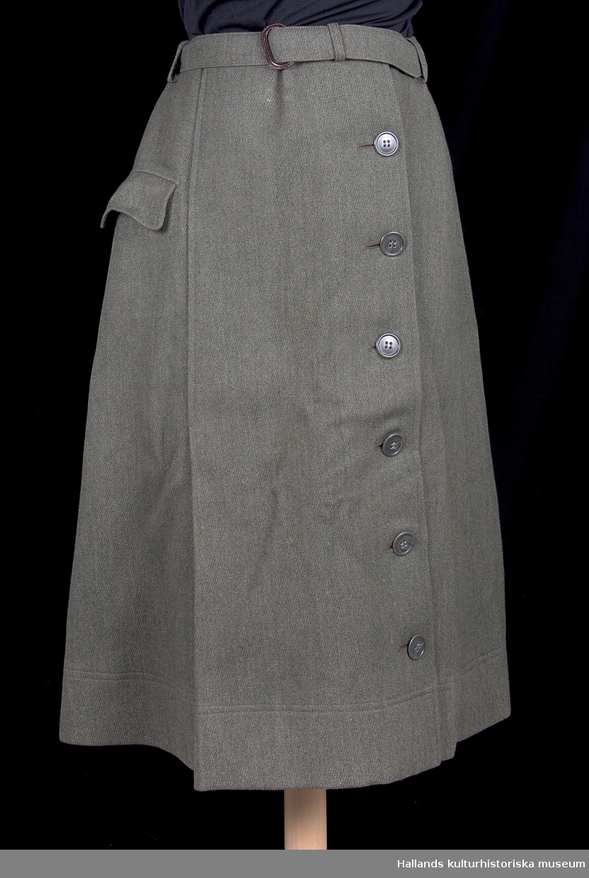 Uniform m/1942 kv. för sjuksköterska.

a) Dubbelknäppt uniformsjacka av grågrön kypertvävd ylle, fodrad med brungrått satintyg. Försedd med grå knappar i syntetmaterial. Krage med slag. Två sidofickor samt två bröstfickor. Skärp i midjan av samma tyg som jackan. På vänster arm ett tygmärke med oljelampa av metall (tjänstetecken m/1946 för sjukvårdspersonal). På jackans insida (vid knäppningen) finns etikett: "PUB. PAUL U. BERGSTRÖMS A-B STOCKHOLM". På dess krage: "AND. G. WALLIN. TEL.2692 - HALMSTAD".

b) Kjol. Enkelknäppt uniformskjol av grågrönt kypertvävt ylle med skärp av samma material. Försedd framtill med 6 stycken knappar av syntetmaterial. Ficka på höger sida. Veckad nedtill på höger sida. I linningen en etikett: "PUB. PAUL U. BERGSTRÖMS A-B STOCKHOLM".

c) Fältmössa. Båtmössa av grågrönt kypertvävt ylle. På insidan en etikett: "PUB. PAUL U. BERGSTRÖMS A-B STOCKHOLM".