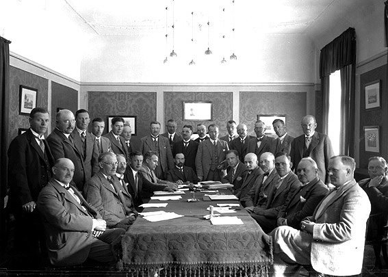 Större grupp män vid förhandlingsbord.