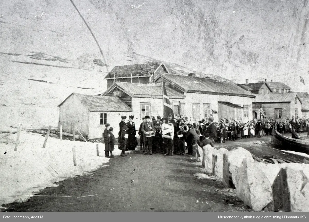 Honningsvåg, Toklebuene. Musikk-korpset i 17. mai-tog. På høyre sider ligger båter i fjære. 1899/1900.