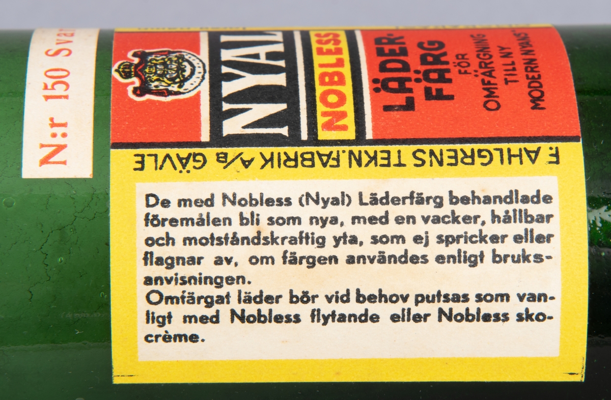 Glasflaska, grön, med kork. Etikett med text "Nyal Nobless Läderfärg".