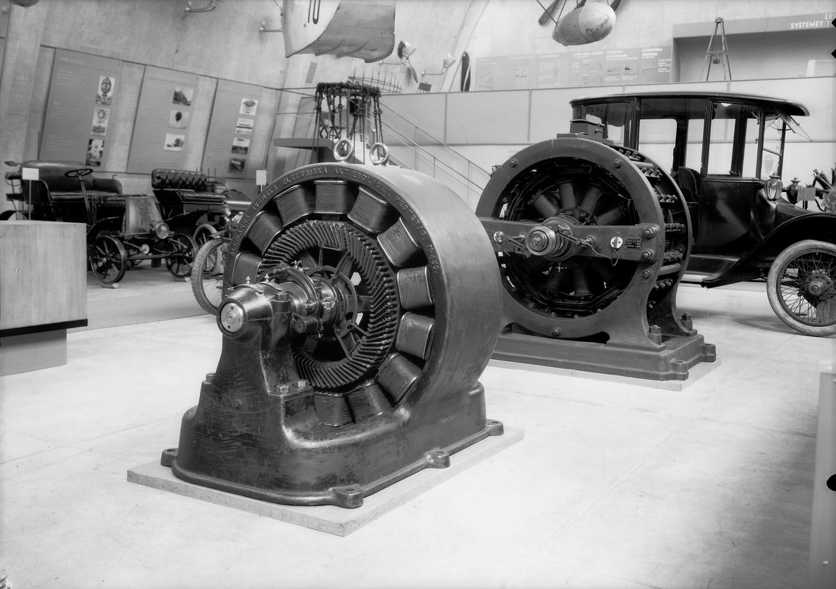 Tekniska museet, ca 1939. Del av utställning i maskinhallen, elgeneratorer och elbil.
