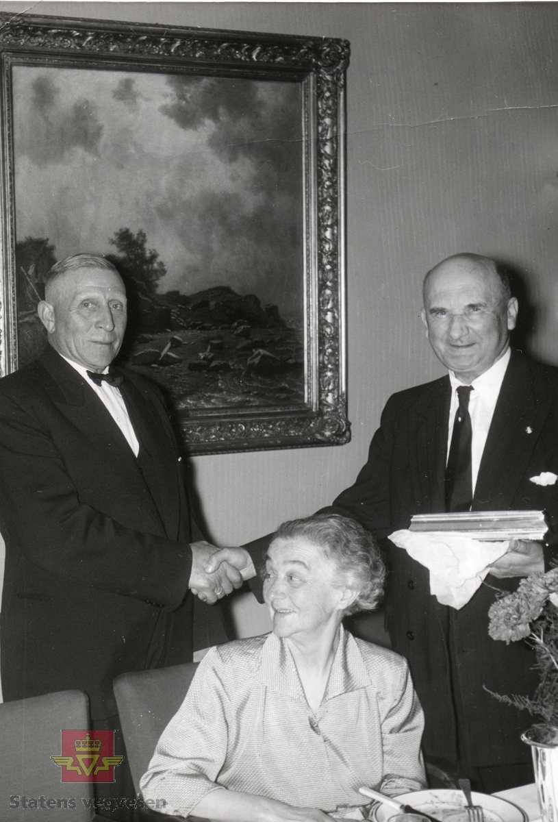 Gaveoverrekkelse til vegsjef Olav Ødegård ved  hans fratredelse  i 1956. 
Fra venstre: Lars Lillehammer, fru Ødegård og Olav Ødegård.