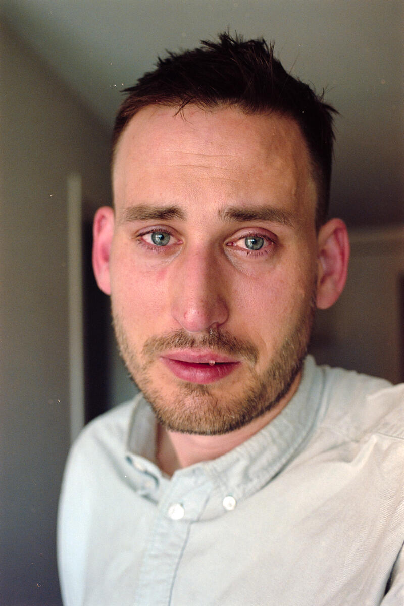 Nærportrett av en mann med tårer i øynene og et sårt uttrykk