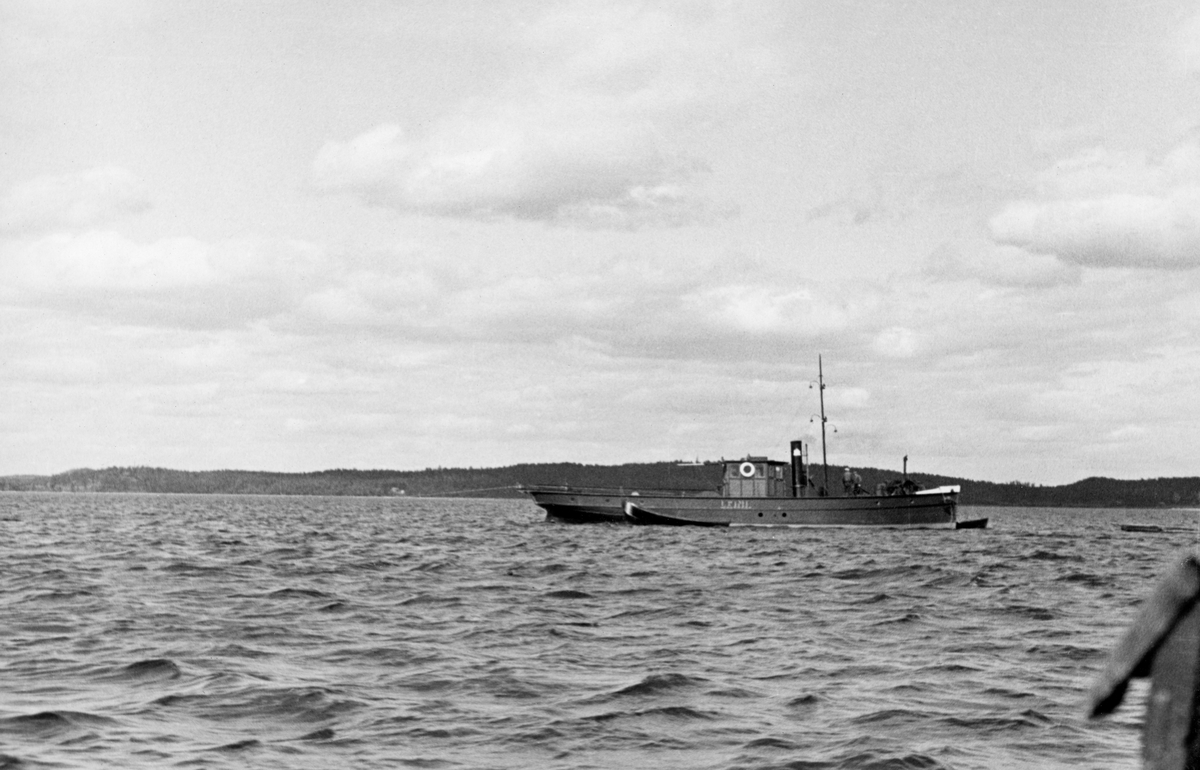 Fartøy «Leini» fotografert på sjøen Kirkkojärvi i Finland. Dette stedsnavnet er det flere av de finske sjøene som har, og vi vet ikke hvilken av dem dette dreier seg om. Det vi vet er at fotografiet ble tatt under en ekskursjon norske fløtingsfunksjonærer avviklet i Sør-Finland i 1934. Derfor er det kanskje også grunn til å anta at dette var en slepe- eller bukserbåt som ble brukt til å trekke tømmer over et stort vannspeil. Det ser ut til at være en dampdrevet båt med stålskrog. Da fotografiet ble tatt lå det også to robåter av tre ved fartøyet, ert ved baugen og et ved styrbord side.