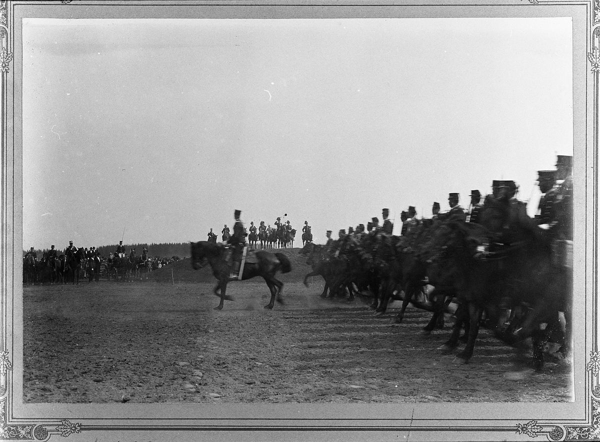 Oplandske Kavallerikorps defilerer for prins Carl ved Avansementshaugen på Gardermoen 19.august 1900. Korpset hadde sitt 150 års jubileum dette året. Se også TM-R79.053.05.