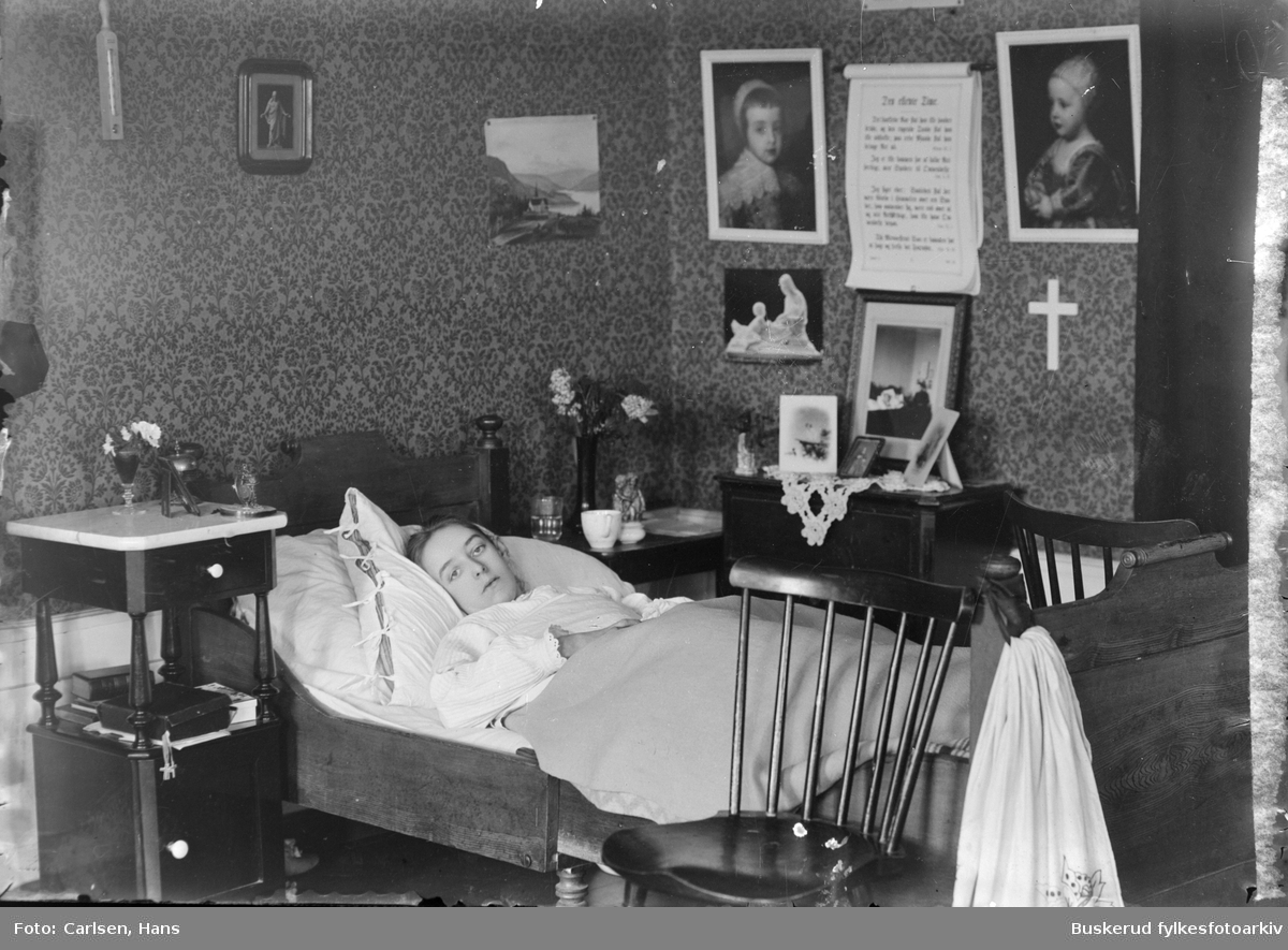 En jente ligger i sin seng. Frk Alsing, datter av prest Alsing.