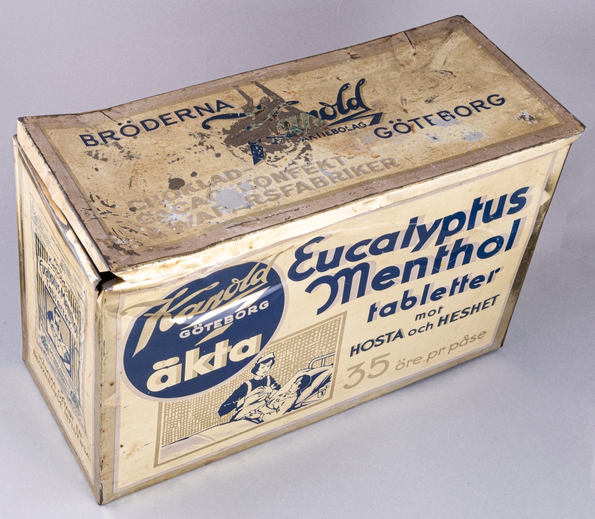 Plåtburk, rektangulär, ljusgul med blå text och mönster. Text på burken: Kandold GÖTEBORG äkta Eucalyptus Menthol tabletter mot HOSTA och HESHET.