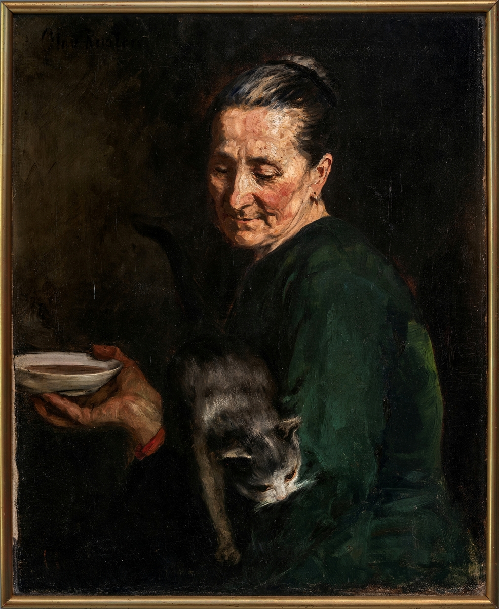 Eldre kvinne i grønn kjole, avskåret ved hoftene. Holder en katt i sin venstre arm, en skål i høyre hånd. Mørk bakgrunn.