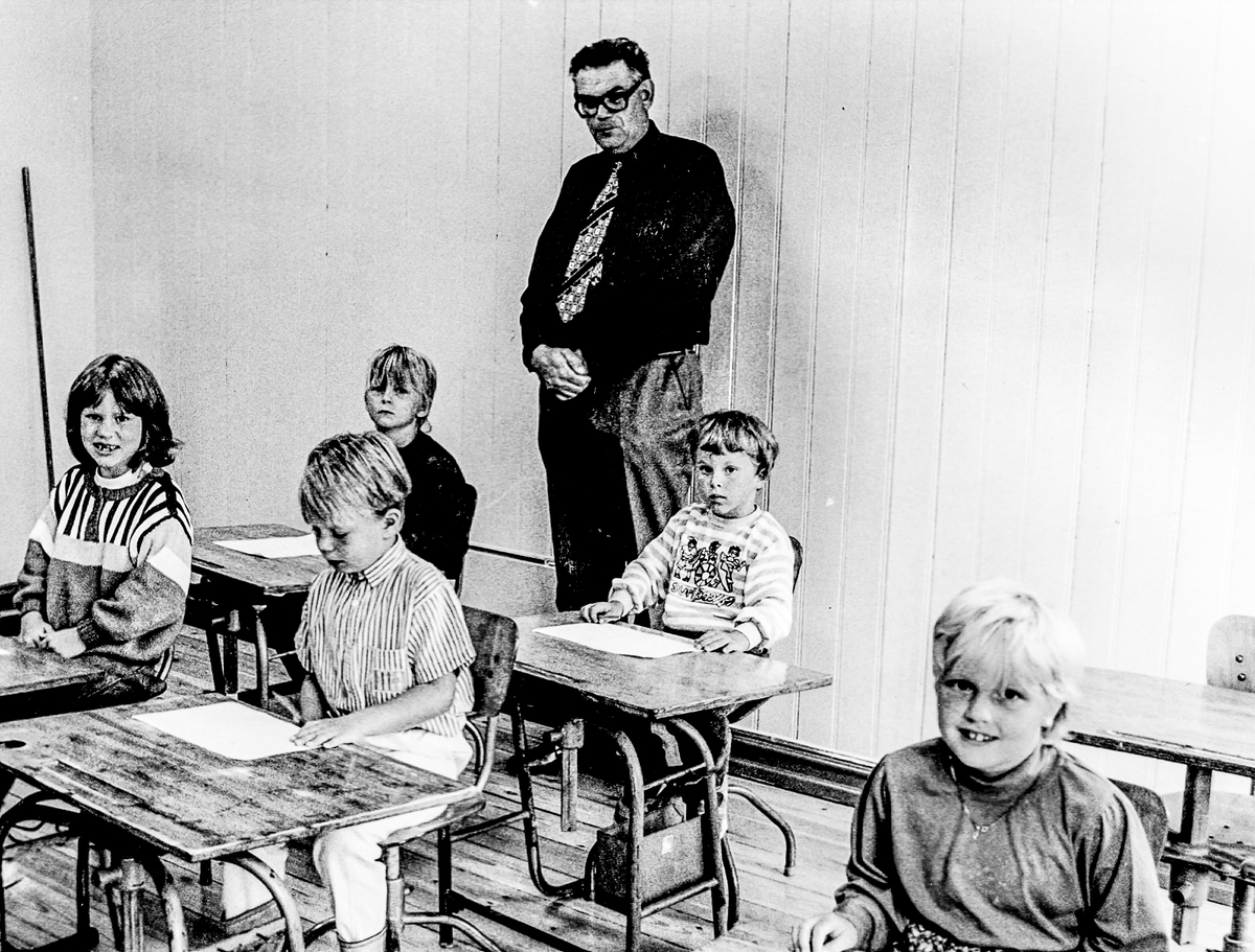 Lærer Anton Klausen i klasserommet på Kjølebrønd skole.1980-85. Spiser bløtekake. Glede over åpnet skole.