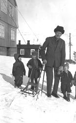 Mann med barn i Longyearbyen. Tekst med bildet: 1. og 2. gen