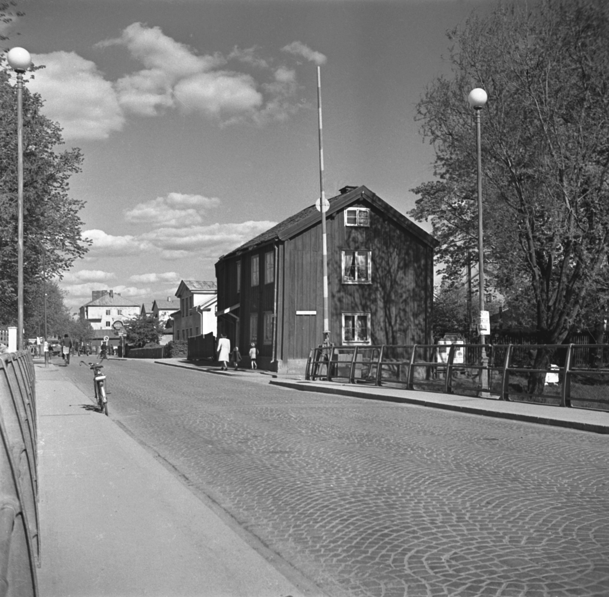 Motiv från Stångebro i Linköping med blicken vänd österut. Till höger platsen för stadens östra tull. Byggnaden i blickfånget uppfördes i slutet av 1830-talet som ersatte då själva tullhuset. Trots att stadstullen tagits bort nästan trettio år tidigare fick den nya byggnaden i folkmun ärva sin föregångares namn. År 1832 flyttade urmakaren Erik Fougelberg (1777-1852) in med sin familj. Efter några år ersatte han den gamla tullstugan med huset på bilden. Odaterad bild från omkring 1950, kort före man lät flytta byggnaden till friluftsmuseet Gamla Linköping.