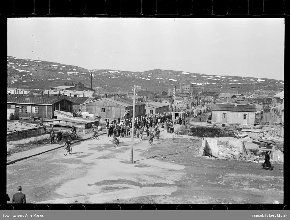 I pinsen (25-26.mai) 1947 ble det avholdt sangerstevne i Kirkenes, der folk kom med huritgruten fra Båtsfjord, Vardø, Vadsø og Honningsvåg. Foto antagelig tatt i denne anledning

Mannskor marsjerer i parade. Framst i paraden kan man se et korps. I bakgrunnen kan man se deler av Dampsentralen (til venstre)