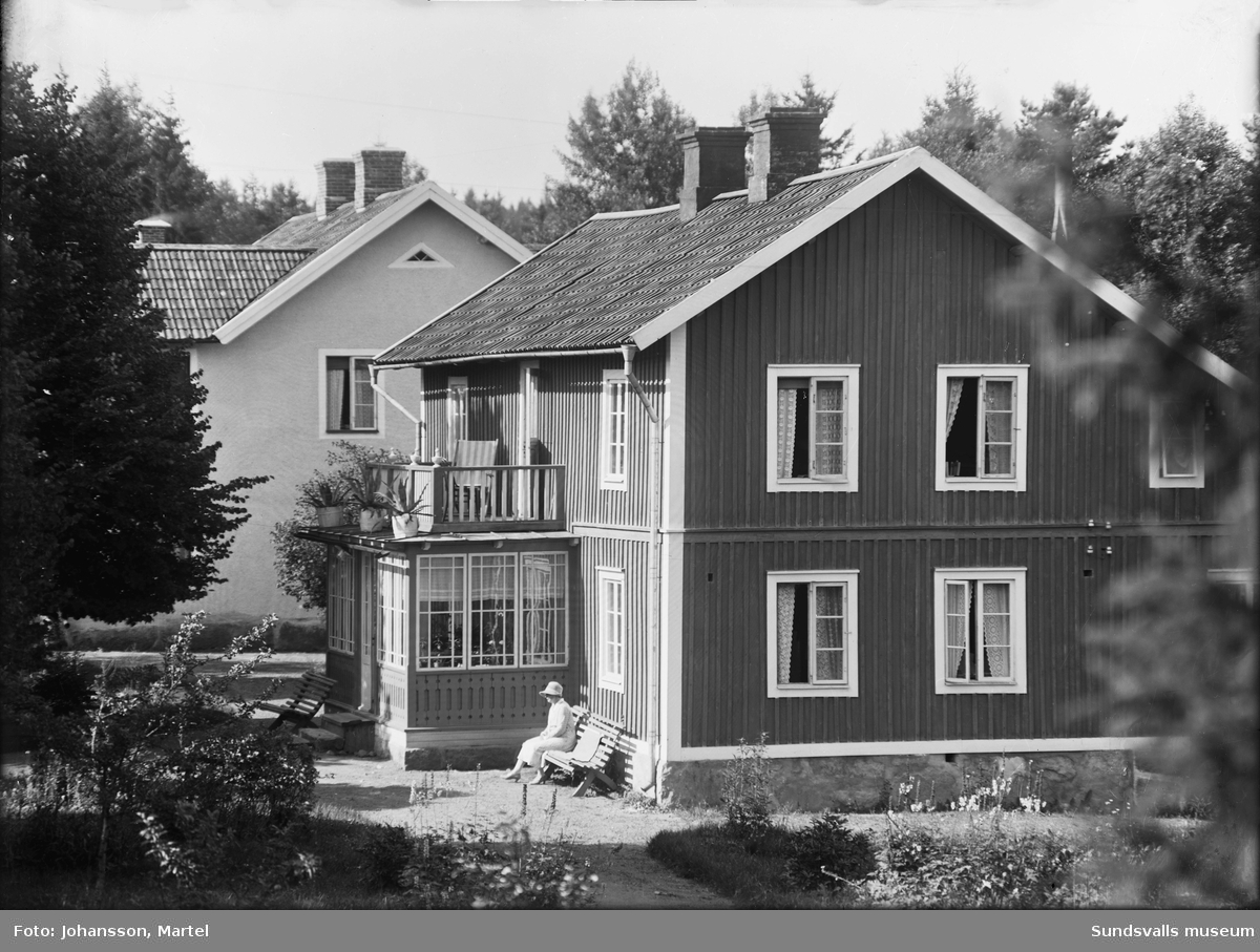 Två bilder av en bostadsbyggnad med glasveranda. På en bänk sitter en kvinna i ljus dräkt och hatt. Den ljusa byggnaden bakom är samma som SuM-foto034836, Villa Göta. Okänt var i Sverige bilden är tagen.