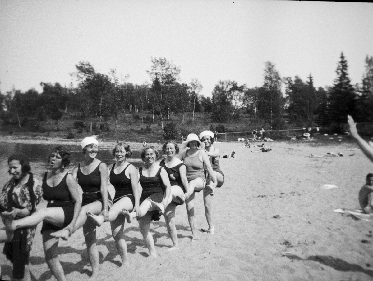 Sju kvinnor står på rad på badstrand, Gräddö, Uppland