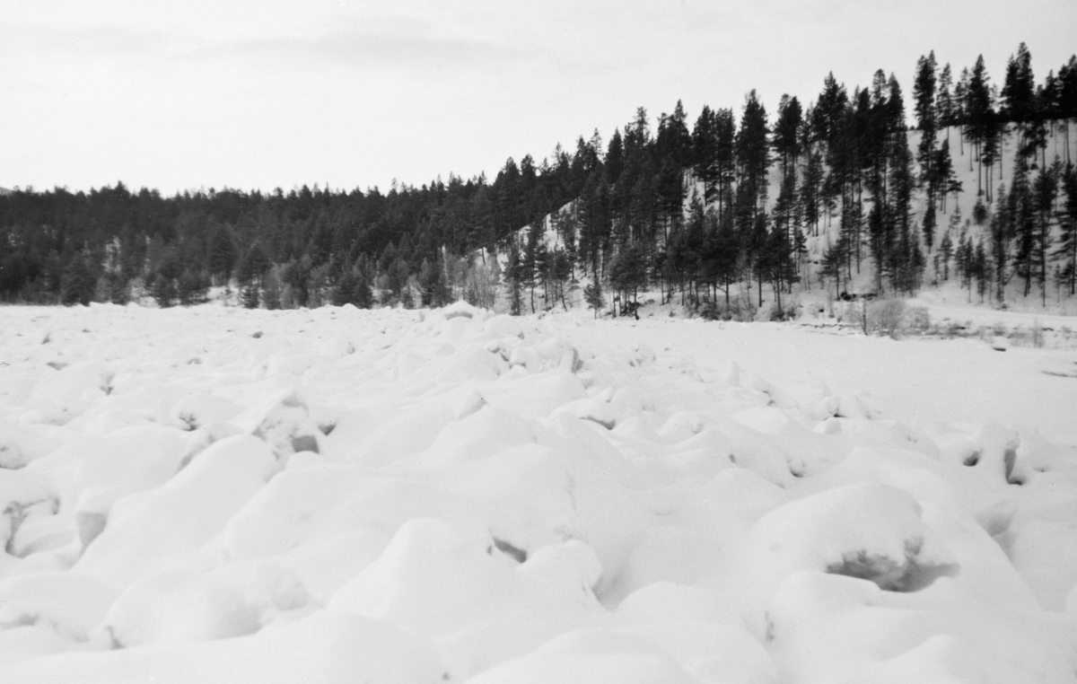 Isgang i Glåma ved Storkvernan i Tolga kommune vinteren 1938. Den ujevne isfata vitner om at dette er et elveløp der det hadde vært isgang. Vinterisgang oppstår i innlandsvassdrag der det er tilstrekkelig fall til at det oppstår sørpeis og sarr (bunnis) med oppstuving og tilløp til dannelse av dammer. I den øvre delen av Glåma opplevdes dette som et stadig større problem etter at vassdraget ble regulert. Ettersom isen, når den kommer i sig, kan gjøre store skader langs vassdragene, ble eierne av Aursunddammen pålagt å manøvrere slik at naturlig vannføring ble opprettholdt inntil isforholdene nedover i vassdraget hadde stabilisert seg, vanligvis i desember måned. Deretter kunne tappinga økes trinnvis – fra 11 til 16 kubikkmeter i sekundet - til beste for elektrisitetsproduksjonen. Isgangsproblematikken var aktuell i 1938, for da ble det framlagt planer for flere kraftverk i den nordre delen av vassdraget, ved Eidefossen på Tolga og ved Barkaldfossen i Alvdal.