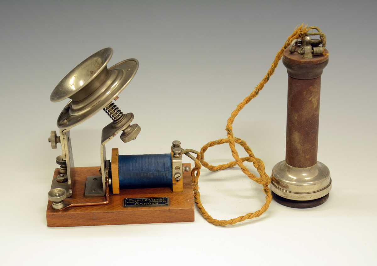 Demonstrasjonsmodell av telefon. Består av 2 deler, en med mikrofon med en spole montert på treplate, den andre en høretelefon.