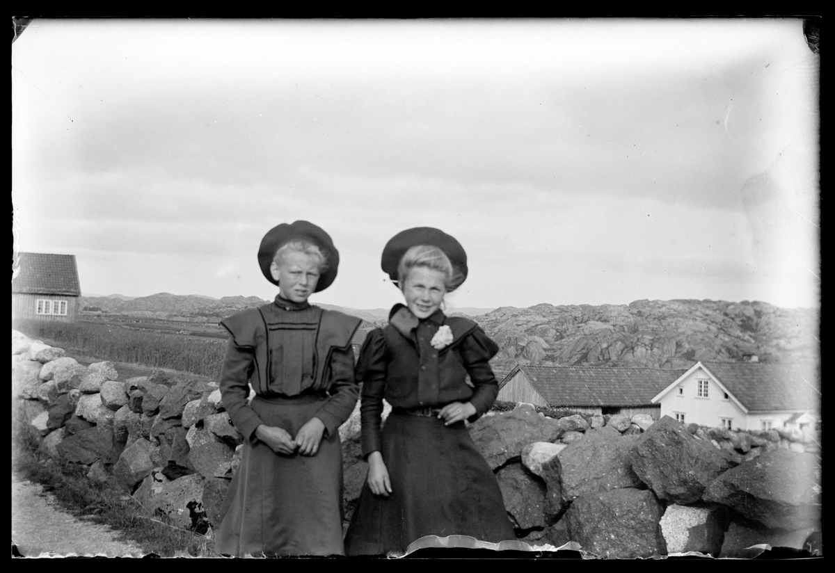 To piker foran steingjerde på Eigerøy