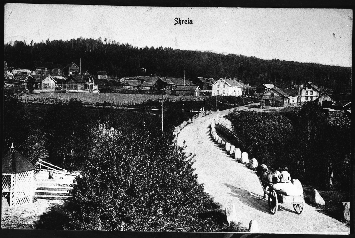 Skreia sentrum, trolig tidlig 1900-tall. I forgrunnen en hesteskyss på veg ut på brua over Lenaelva.