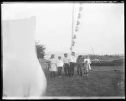 Gruppebilde av barn foran flaggstang