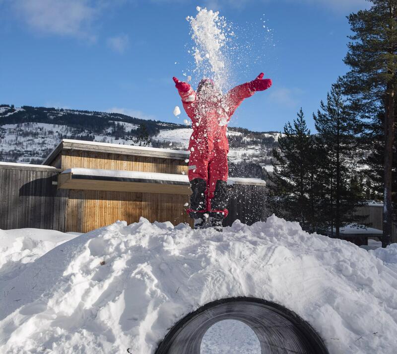Bildet viser et barn som leker med snø i museumsparken