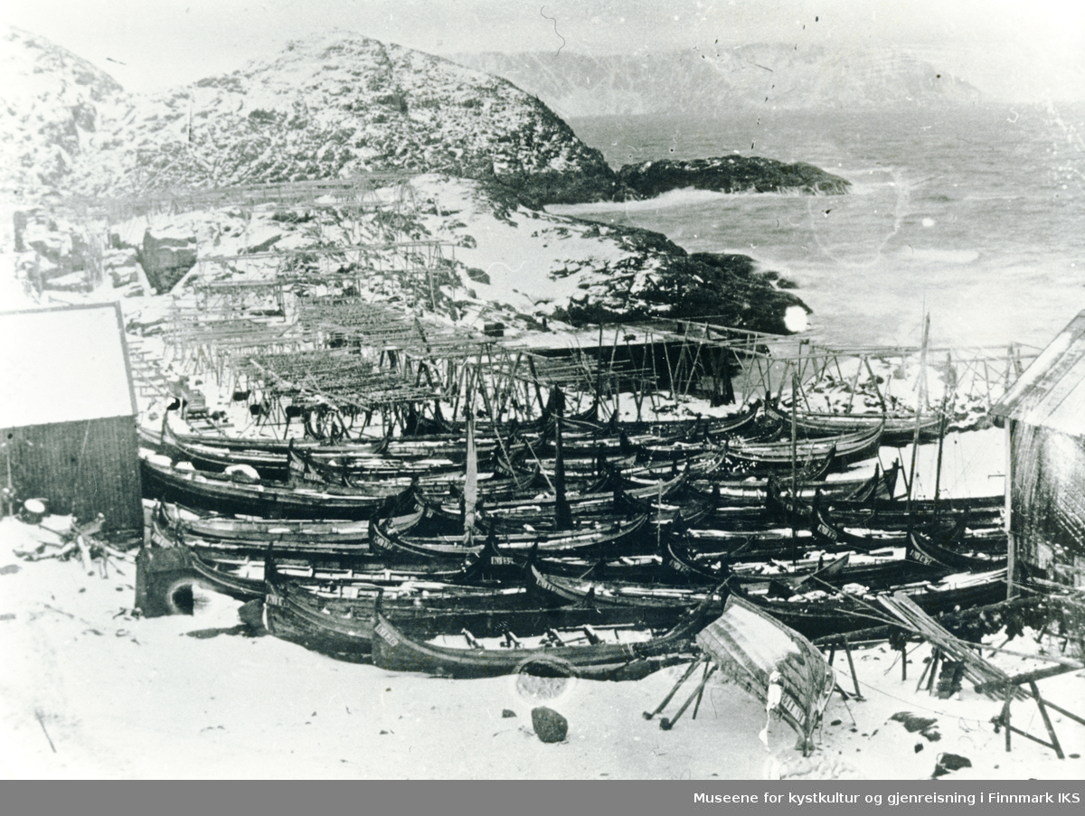 Helnes med fiskehjeller og mange Nordlandsbåter trukket på land. Omkring 1900.