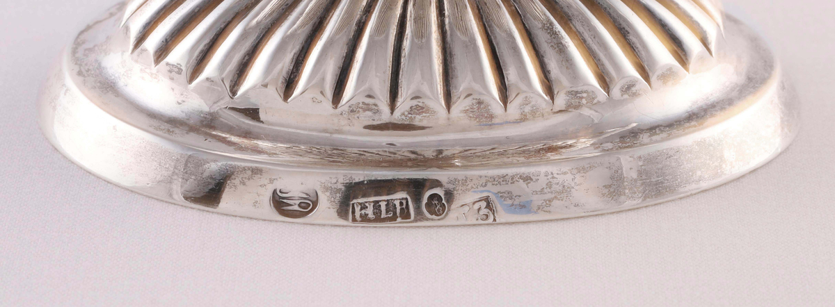 Gräddkanna i silver. Empire. Tillverkad 1825. Invändigt förgylld. Kaskformad skål som uppbäres av delfin och oval fot. Uppsvängd räfflad hänkel. Skålens underdel och fot med godronnering. Fotens ena kant stämplad: "Ullsaxar / HLB / 3 kronor / T3". Den andra kanten graverad: "L U S T".

Proveniens:
Givarens mor, som i sin tur ärvt gräddkannan av sin faster, som i sin tur ärvt den av släktingar i Svenljunga på 1800-talet.

Äldre historik:
Silversmeden Hans Israel Lyberg föddes 1781 i Borås. Var son till silversmeden Samuel Lyberg (1750-1834) som i sin tur var son till silversmeden Israel Lyberg (1717-1765) i Gränna. Hans Israel Lyberg stämplade i Borås från 1806 och var gift med Brita Catharina Hasselqvist. Lyberg blev ålderman för sitt skrå och avled i Borås 1848.

Litteratur:
Silver från Borås och Ulricehamn 1966. Sidan 61, nummer 230.