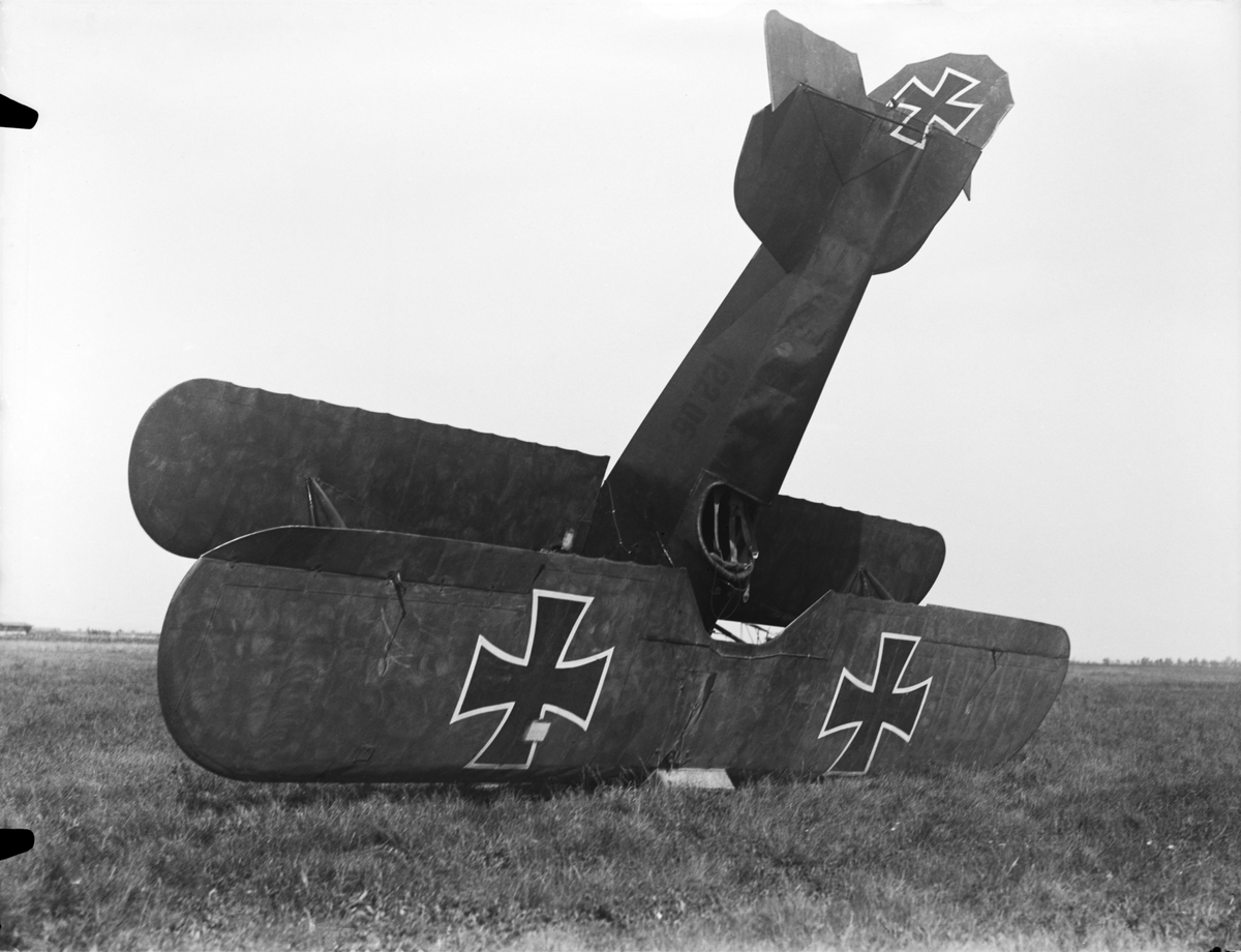 Militärt flygplan Phönix D.I märkt 122.06 tillhörande Österrike-Ungern står på nosen på ett fält, efter haveri. Vy framifrån.