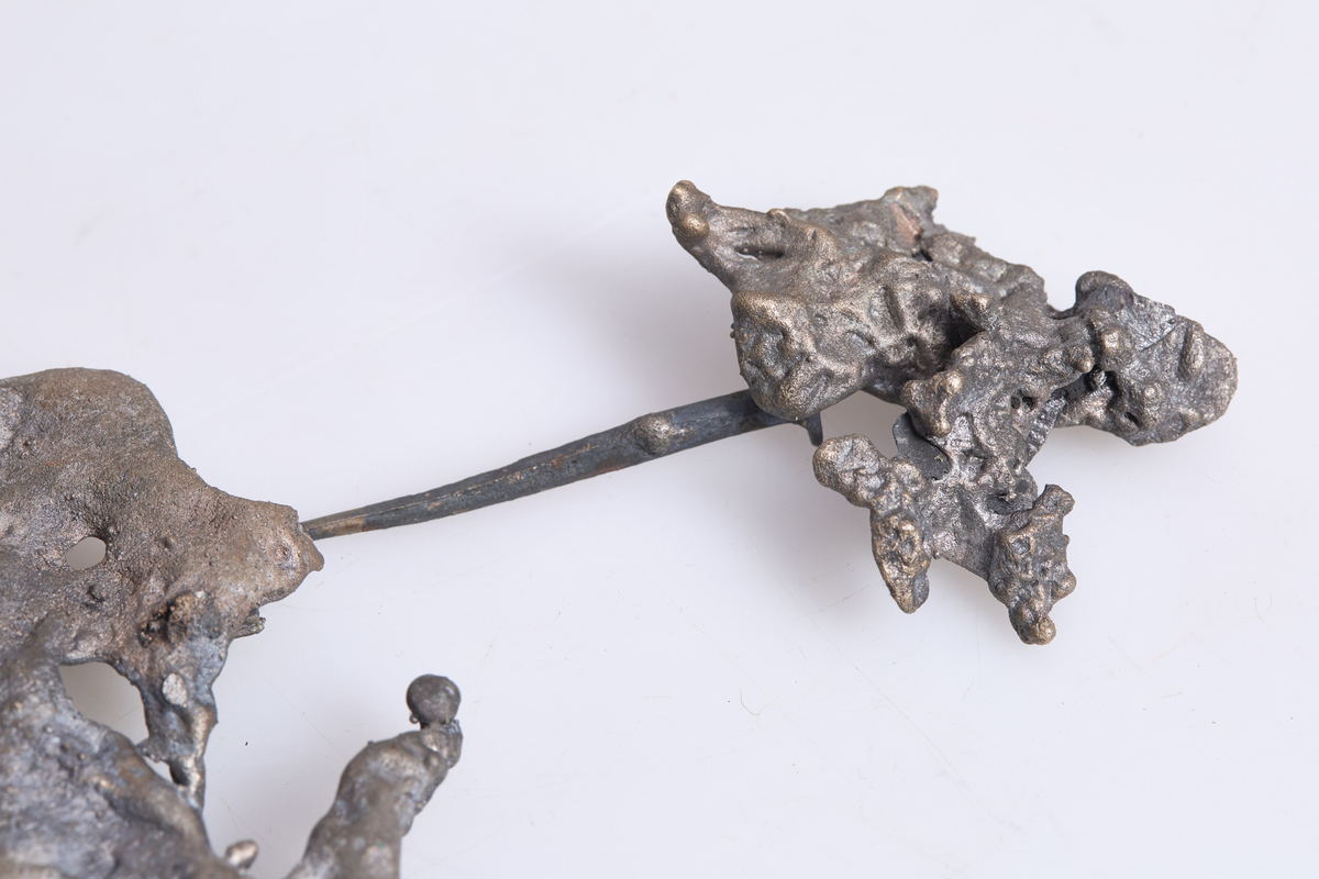 Rester av gammel nøkkel fra Aas kirke i V.Toten som brant i 1915 og det meste av inventaret ble ødelagt, nøkkelen er smeltet, deformert og i to deler.