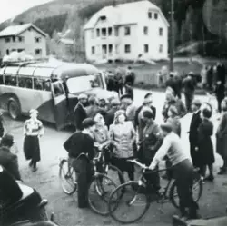 Gruppe,sykkler,buss og bolighus 9 mai 1945.