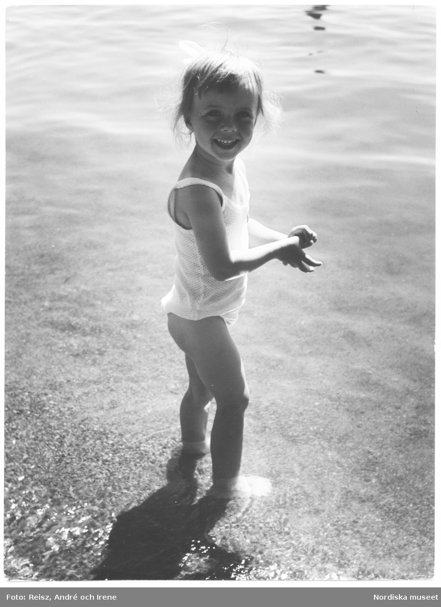 En liten flicka står i vattnet.