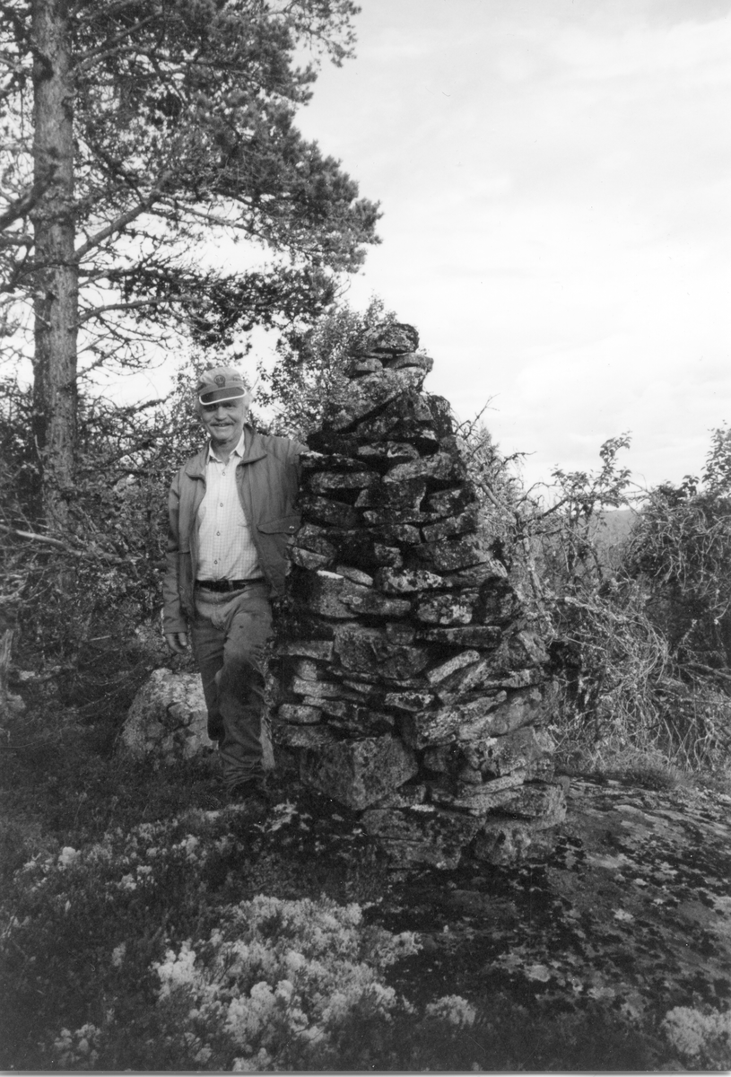 Arne Horge ved varden ovenfor Gamlevollen i Skirvedalen.
Varden er bygd i 1915 av brødrene Sandanbråten, da de satt på stølen der. Her var mer enn nok stein å ta av. De prøve bryte opp vollen, men det kom opp så mye stein at de måtte gi opp.
