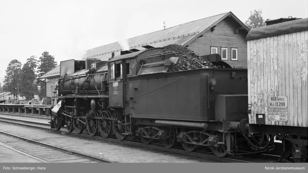 Damplokomotiv type 26a nr. 215 med persontog fra Oslo Ø til Trondheim, tog 301, på Koppang stasjon. Nærmest lokomotivet godsvogn litra Hv3 nr. 13299