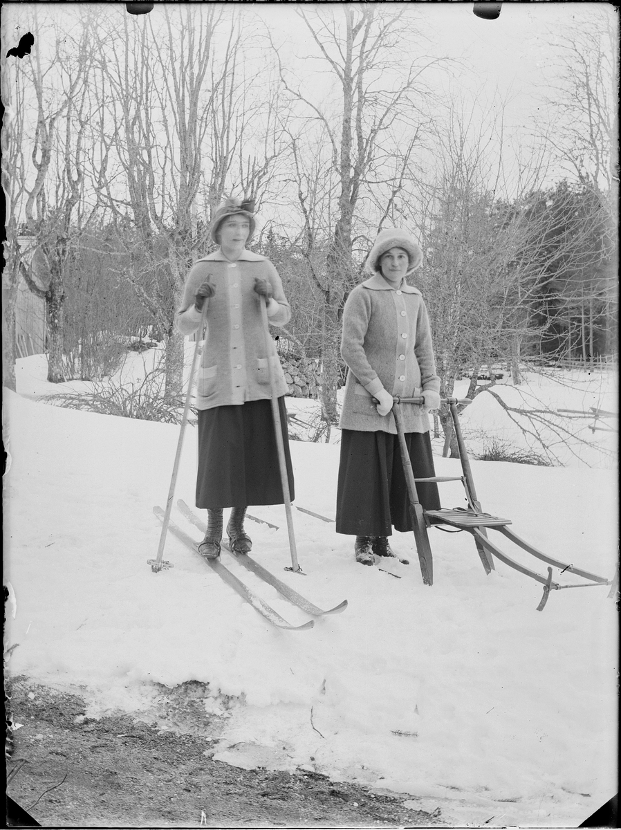 Två kvinnor åker skidor och sparkstötting, Alunda, Uppland